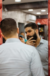 A bearded man looking at himself in the morror
