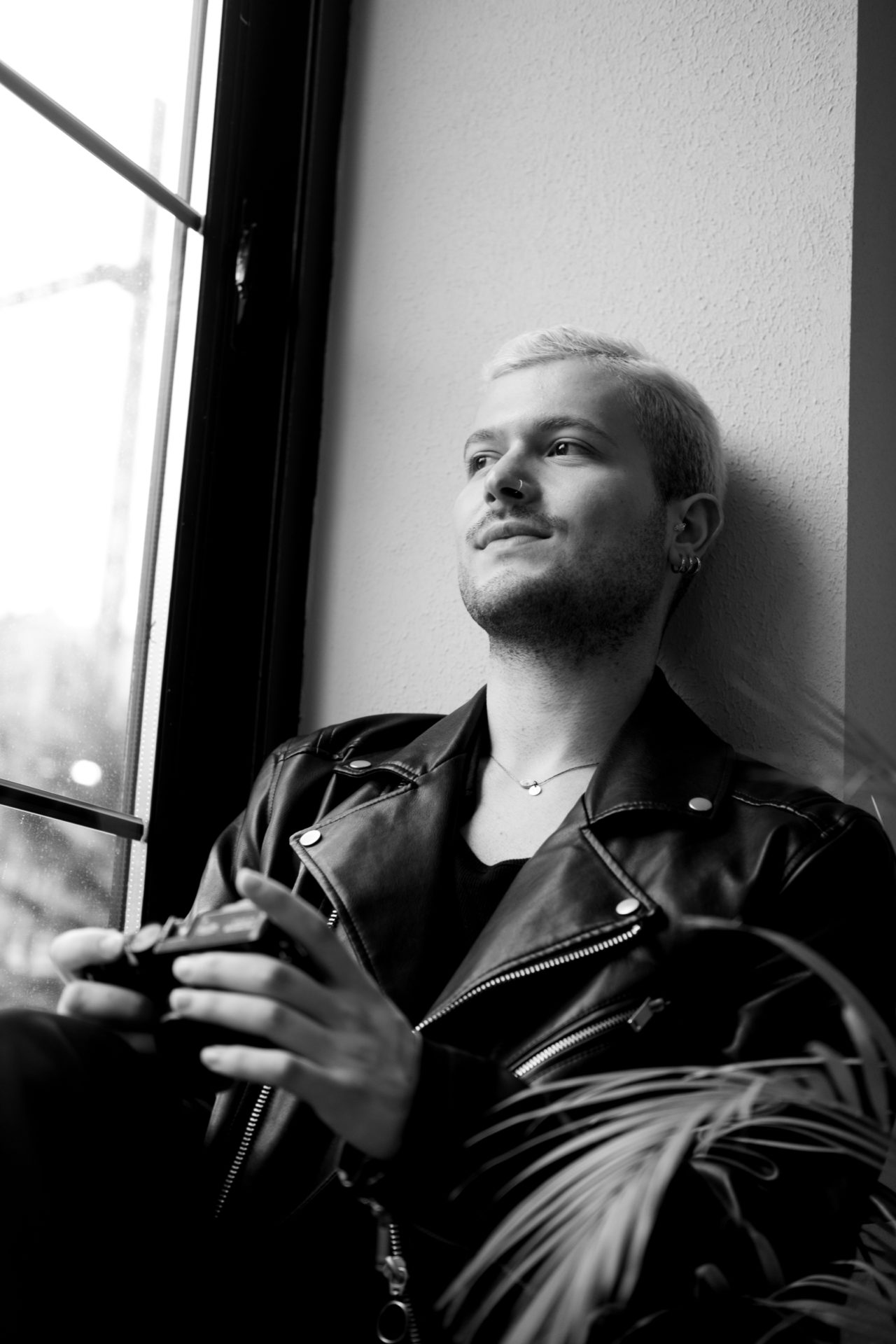 Black and white photo of a man sitting in the window