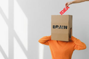 Box with brain inscription on head of anonymous woman