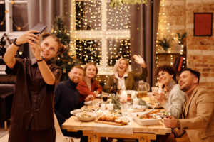 Family celebrating christmas dinner while taking selfie