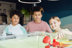 Group of schoolkids playing with new robots