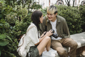 Happy multiethnic couple speaking on street bench in park