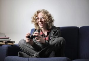 Joyful teenager playing video game on tv console