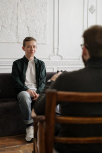 Man in black sweater sitting on brown wooden chair