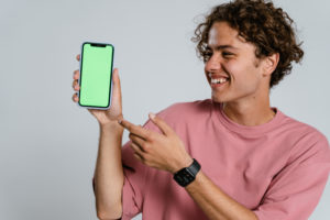 Man in pink crew neck t shirt holding blue iphone case