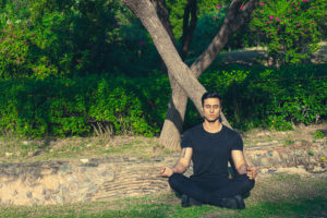 Man sitting beside the trees