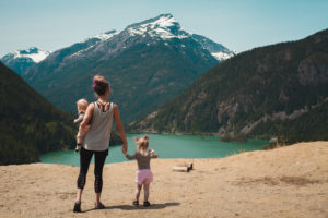 Mother and children walks near body of water