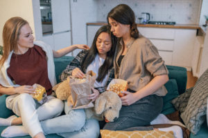 Photo of women eating popcorn while comforting their friend
