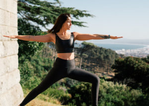 Woman in black sports bra and black leggings doing yoga