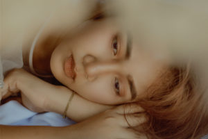 Crop wistful asian woman lying on bed