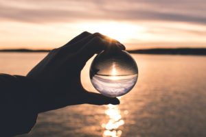 Photo displays person holding ball with reflection of horizon