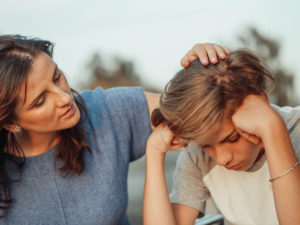 Woman in blue shirt talking to a young man in white shirt