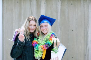 Woman wearing blue mortarboard cap standing near woman wearing blue jacket